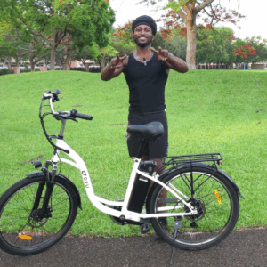 Devar Davis with the DYU C6 Electric Bike after a smooth outdoor ride — eco-friendly comfort and mobility in action.